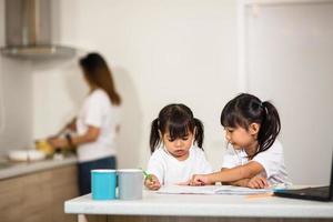 covid-19 coronavirus e apprendimento da casa, concetto di bambino a scuola a casa. i bambini piccoli studiano online imparando da casa con il laptop. foto