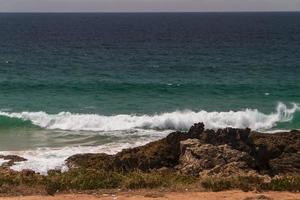 le onde che combattono sulla costa rocciosa deserta dell'Oceano Atlantico, in Portogallo foto