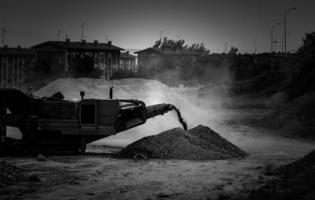 escavatore e polvere in un cantiere foto