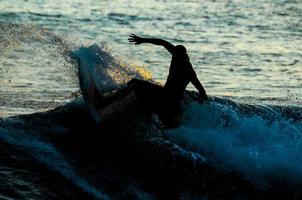 surfista di sagoma al tramonto foto