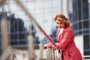 una bella donna adulta con un caldo cappotto rosso ha camminato in città durante i fine settimana foto
