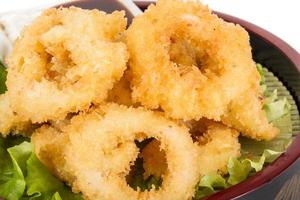 Anelli di calamari fritti in pastella con insalata verde foto