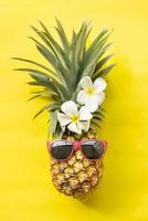 hipster di ananas in occhiali da sole, moda. frutta alla moda. concetto minimo, ananas tropicale estivo. concetto di vacanza alla moda di arte creativa. umore del colore estivo, frutta di ananas. foto