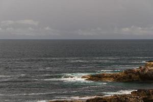 le onde che combattono sulla costa rocciosa deserta dell'Oceano Atlantico, in Portogallo foto