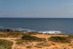 le onde che combattono sulla costa rocciosa deserta dell'Oceano Atlantico, in Portogallo foto