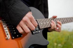 primo piano di un uomo che suona la chitarra foto