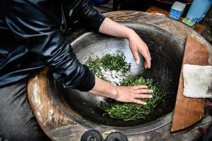 tradizionale preparazione del tè essiccazione del tè verde in padella lavorazione a mano nel villaggio di longjing a Hangzhou in Cina. foto