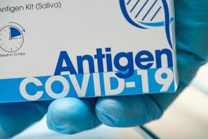 medico in tuta dpi con kit per il test dell'antigene della saliva per il controllo del coronavirus covid-19 in ospedale. foto