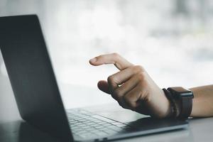 primo piano della mano dell'uomo che punta allo schermo del tablet, uomo d'affari che lavora, digitando sul tablet. il concetto di utilizzo di apparecchiature tecnologiche nel lavoro aziendale. foto