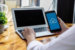 persona che tiene uno smartphone davanti a un'applicazione di archiviazione cloud, utilizzando uno smartphone per archiviare dati tramite cloud. concetto di utilizzo di smartphone e applicazioni di archiviazione dati. foto