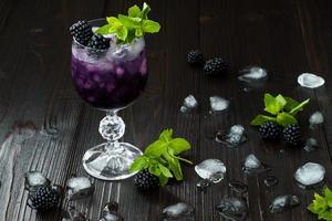 Blackberry cocktail nel bicchiere di vino con menta e ghiaccio