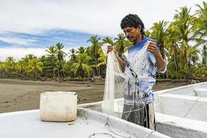 un pescatore locale rustico che prepara la sua rete foto