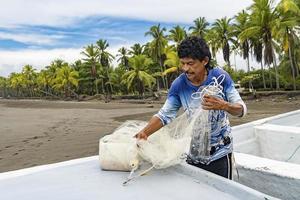 pescatore concentrato che prepara la sua rete nella sua barca. foto