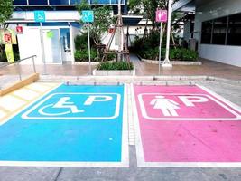 Bangkok, Tailandia - 27 agosto 2016 segno parcheggio auto. lo spazio riservato ai disabili parcheggio e parcheggio signora davanti al bagno pubblico e al bagno per disabili foto