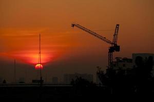 gru in cantiere al tramonto foto