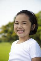 la ragazza asiatica si rilassa e sorride felicemente nel parco foto