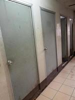 la porta sporca in pvc della toilette provvisoria della stazione dei treni. foto