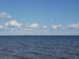 nuvole nel cielo azzurro e nell'acqua. lago o mare foto
