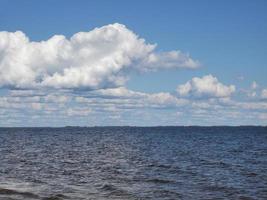 nuvole nel cielo azzurro e nell'acqua. lago o mare foto