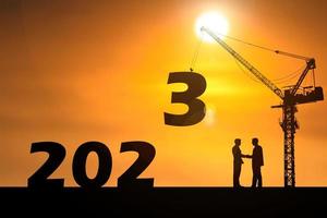 felice anno nuovo 2023 concetto. gli uomini d'affari si uniscono. riuscito a contattare il lavoro foto