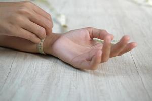 polso di misurazione della mano femminile con un metro a nastro foto