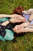 due allegre sorelle sdraiate sull'erba foto