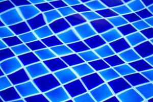 sfondo astratto dalla piscina piastrellata blu con acqua limpida increspata foto