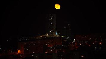 paesaggio urbano notturno con una bella luna nel cielo foto