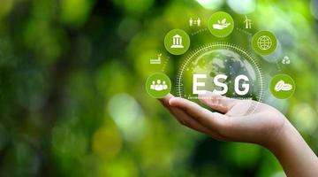 concetto di icona esg in mano per ambiente, sociale e governance in risorse sostenibili e rinnovabili e icone di rete su sfondo verde. foto