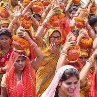 nuova delhi, india 03 aprile 2022 - donne con kalash sulla testa durante il tempio di jagannath mangal kalash yatra, devoti indù indiani portano pentole di terracotta contenenti acqua sacra con una noce di cocco in cima foto