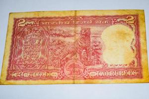 vecchie banconote da due rupie combinate sul tavolo, denaro indiano sul tavolo rotante. vecchie banconote in valuta indiana su una tavola rotante, valuta indiana sul tavolo foto