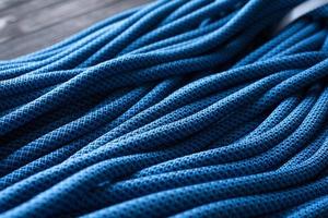 sdraiato sul tavolo di legno. foto isolata di nodi rampicanti. vista dall'alto di cavi di colore blu