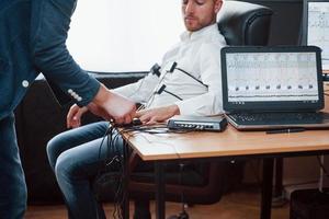 le dita per favore. preparazione per il test del poligrafo. concezione della macchina della verità foto