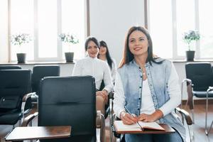 informazione interessante. gruppo di persone alla conferenza di lavoro nella moderna classe durante il giorno foto