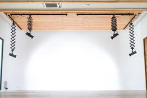 la sala dello studio professionale appende il soffitto in legno a forma di luce a led con la parete bianca a sfioro dietro. foto