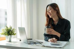 concetto di contabilità aziendale, donna d'affari che utilizza calcolatrice e computer portatile per budget e carta di prestito in ufficio. foto