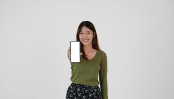 l'immagine di una giovane ragazza asiatica in possesso di smartphone mostra uno schermo bianco vuoto su sfondo bianco. foto