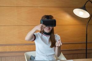 giovane donna eccitata con occhiali vr che guida l'auto nella realtà virtuale. signora che urla quando gira il volante virtuale, adolescente che gioca in giochi per computer da corsa o simulatore di strada, godendo di giochi 3d foto