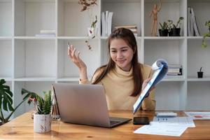 la donna asiatica di affari che dà la presentazione online discute il rapporto finanziario che parla effettua la videochiamata della conferenza. foto