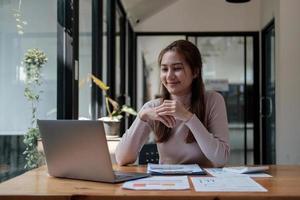 la donna asiatica di affari che dà la presentazione online discute il rapporto finanziario che parla effettua la videochiamata della conferenza. foto