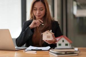 concetto bancario di contabilità di finanziamento delle imprese, donna d'affari che fa finanze e calcola i costi per gli investimenti immobiliari e le tasse foto