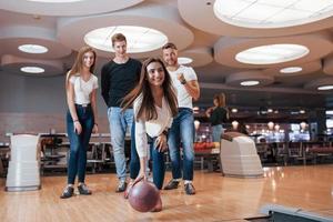 squadra felice. i giovani amici allegri si divertono al bowling club durante i fine settimana foto