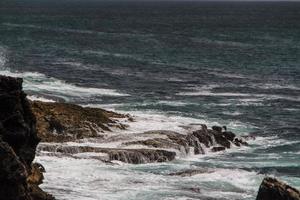 le onde che combattono sulla costa rocciosa deserta dell'Oceano Atlantico, in Portogallo foto