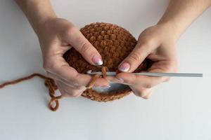 il processo di lavorazione a maglia di giocattoli per bambini con filati di peluche. testa per maglieria. fatto a mano foto