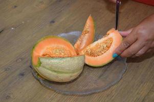 una donna ha tagliato un melone foto