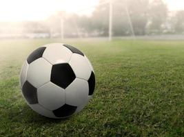 pallone da calcio su un campo in erba, sotto il tramonto foto