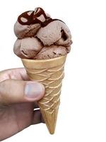 una mano d'uomo che tiene un cono gelato su uno sfondo bianco foto