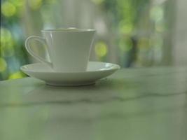 tazza di caffè messa su un tavolo di marmo, bokeh con sfondo sfocato foto