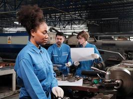 una giovane lavoratrice professionista dell'industria lavora in uniforme di sicurezza con strumenti di precisione per la lavorazione dei metalli, macchine per tornio meccanico e officina di pezzi di ricambio nella fabbrica di produzione dell'acciaio. foto