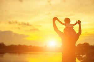 il padre ha preso il bambino impara a camminare al tramonto. foto